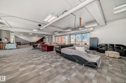 Spacious open-concept room featuring patterned carpet flooring and expansive windows - 