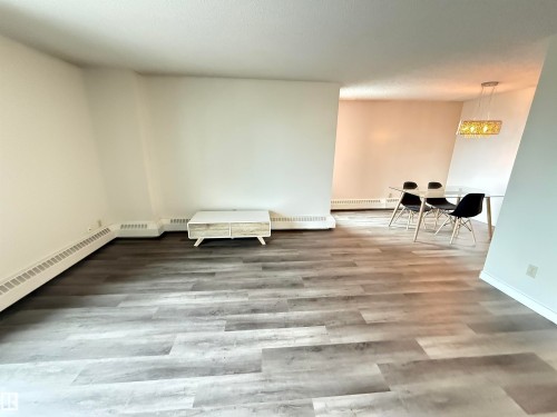 Spacious interior with neutral wall tones and wood-finish flooring - 706 10125 109 Street, Edmonton, AB 