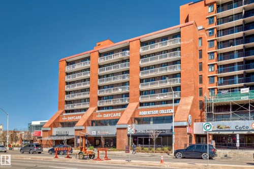 Mid-rise brick building featuring multiple balconies with white railings - 706 10125 109 Street, Edmonton, AB 