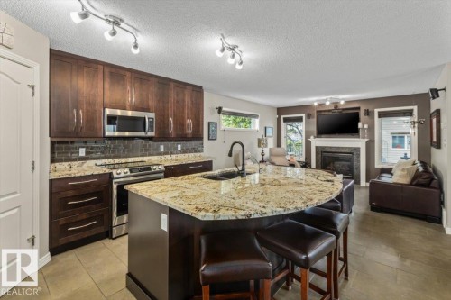 Kitchen island with a granite countertop and integrated sink - 1086 Grantham Drive, Edmonton, AB 