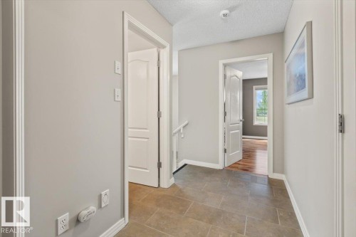 Tiled flooring throughout the hallway with light gray painted walls - 1086 Grantham Drive, Edmonton, AB 