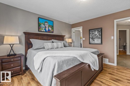 Spacious room featuring wood-finish flooring, two-tone painted walls, and white trim - 1086 Grantham Drive, Edmonton, AB 