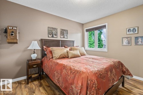 Bedroom featuring wood-finish flooring, a double window with blinds, and neutral-toned walls - 1086 Grantham Drive, Edmonton, AB 