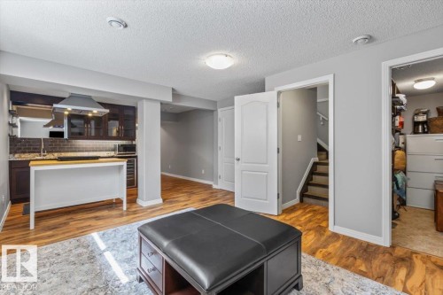 Finished basement featuring wood-finish flooring and light gray painted walls - 1086 Grantham Drive, Edmonton, AB 