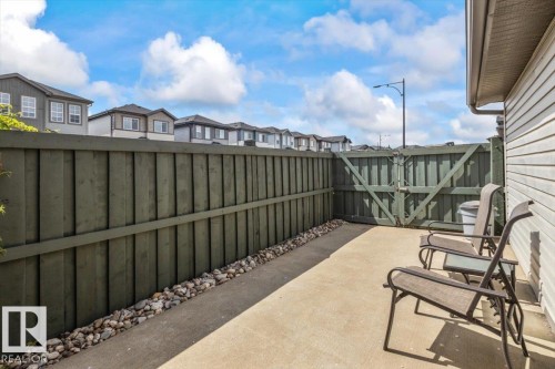 Outdoor patio space featuring a concrete surface, privacy fencing, and a side gate - 1086 Grantham Drive, Edmonton, AB 