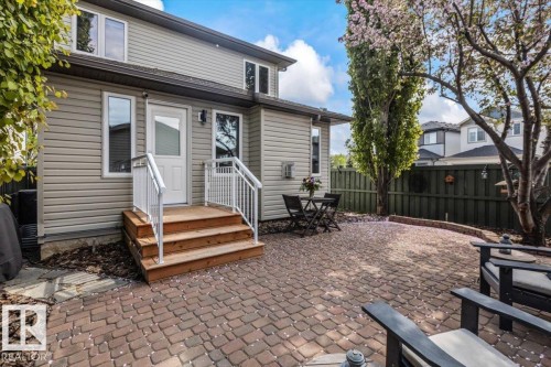 Paved patio area featuring brick pavers and a multi-level wood deck with white railings - 1086 Grantham Drive, Edmonton, AB 