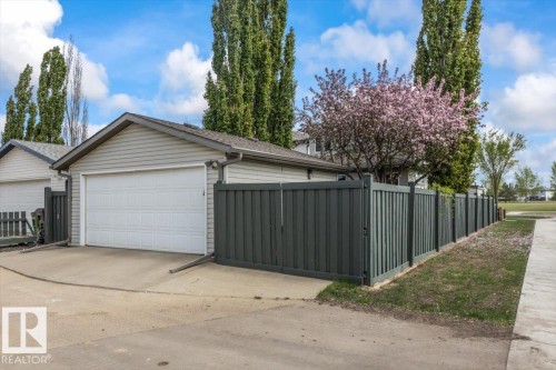 Detached garage with horizontal siding, a white garage door, and a concrete driveway - 1086 Grantham Drive, Edmonton, AB 