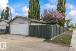 Detached garage with horizontal siding, a white garage door, and a concrete driveway - 