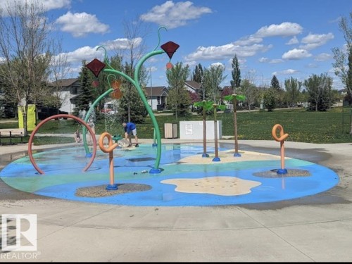 Community splash pad featuring multiple water features, a colorful ground surface, and surrounding green space - 1086 Grantham Drive, Edmonton, AB 