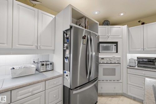 Kitchen featuring white cabinetry with under-cabinet lighting, stainless steel appliances, and integrated microwave and oven - 78 Goodridge Drive, St. Albert, AB 