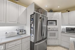 Kitchen featuring white cabinetry with under-cabinet lighting, stainless steel appliances, and integrated microwave and oven - 