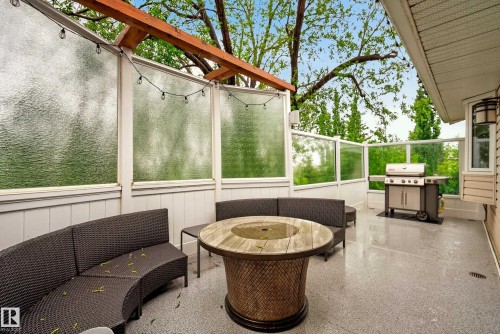 Spacious outdoor deck featuring a textured epoxy flooring, clear glass railings, and frosted glass privacy panels - 78 Goodridge Drive, St. Albert, AB 