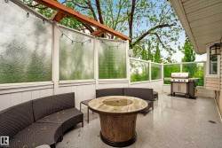 Spacious outdoor deck featuring a textured epoxy flooring, clear glass railings, and frosted glass privacy panels - 