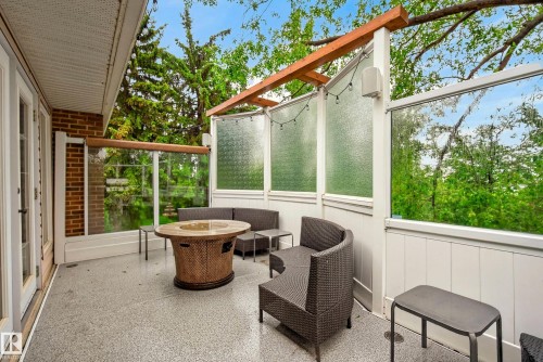 Outdoor patio featuring a speckled concrete surface, white trim, and a brick exterior wall - 78 Goodridge Drive, St. Albert, AB 