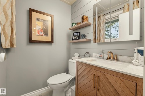 Contemporary vanity featuring a chevron wood-finish facade, integrated rectangular sink, and a light-toned countertop - 78 Goodridge Drive, St. Albert, AB 