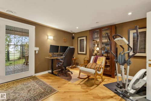 Hardwood flooring throughout this versatile space, featuring a full-light patio door leading to a paved outdoor area - 78 Goodridge Drive, St. Albert, AB 