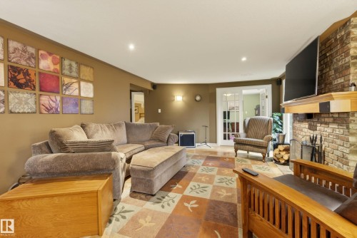 Living area featuring a brick fireplace with a wood mantle, recessed lighting, and a patterned area rug - 78 Goodridge Drive, St. Albert, AB 