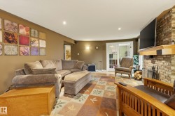 Living area featuring a brick fireplace with a wood mantle, recessed lighting, and a patterned area rug - 