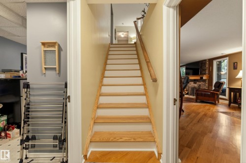 Hardwood staircase with natural wood treads and risers, complemented by a wood-finish handrail - 78 Goodridge Drive, St. Albert, AB 