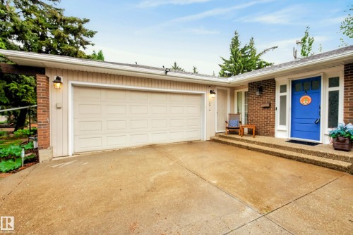 Expansive concrete driveway leading to an attached garage and brick facade entry - 78 Goodridge Drive, St. Albert, AB 