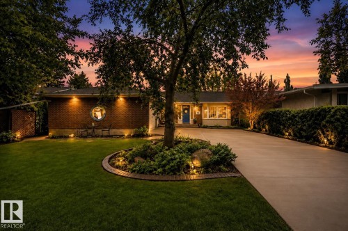 Brick and siding exterior featuring a round window, mature landscaping, a concrete driveway, and integrated exterior lighting - 78 Goodridge Drive, St. Albert, AB 