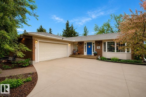 Brick and siding exterior featuring a prominent blue entry door, large bay window, and an attached two-car garage - 78 Goodridge Drive, St. Albert, AB 