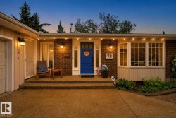 Brick facade with a vibrant blue entry door, an attached garage, a multi-pane bay window, and a concrete driveway - 