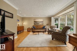 Living area featuring wood-finish flooring, recessed lighting, crown molding, a bay window, and neutral wall tones - 