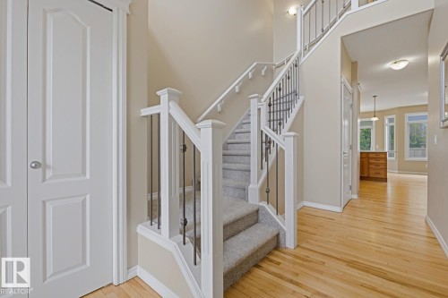 Foyer featuring a grand staircase with white newel posts and black wrought iron balusters - 11612 11 Avenue, Edmonton, AB - Indoor Photo Showing Other Room