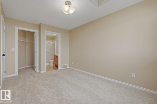 Light-colored carpeting throughout, neutral wall paint, and a semi-flush ceiling light fixture - 11612 11 Avenue, Edmonton, AB - Indoor Photo Showing Other Room