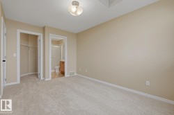 Light-colored carpeting throughout, neutral wall paint, and a semi-flush ceiling light fixture - 