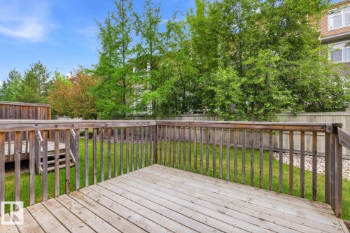 Wood-finish deck with railing overlooking a green lawn, established trees, and a privacy fence - 11612 11 Avenue, Edmonton, AB - Outdoor With Deck Patio Veranda