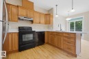 Kitchen featuring wood-finish cabinetry, solid surface countertops, and wood-finish flooring - 11612 11 Avenue, Edmonton, AB  - Indoor Photo Showing Kitchen 