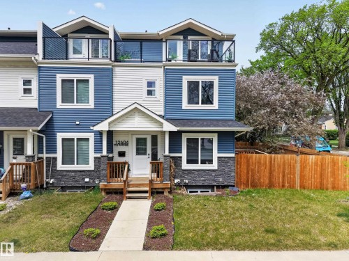 Contemporary townhome with blue siding, white trim, and stone veneer accents - 12604 116 Avenue, Edmonton, AB 