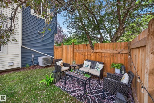Private outdoor patio with a patterned area rug, string lighting, and a wood fence enclosure - 12604 116 Avenue, Edmonton, AB 