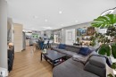 Open-concept living space featuring wood-finish flooring, recessed lighting, and a kitchen with an island, light-toned cabinetry, and stainless steel appliances - 12604 116 Avenue, Edmonton, AB 