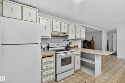 Kitchen featuring white appliances, a light-colored countertop, and two-tone cabinetry with gold-toned hardware - 21 Willowdale Drive, Edmonton, AB - Indoor Photo Showing Kitchen
