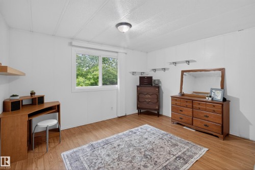 Bright room featuring wood-finish flooring, white paneled walls, and a white ceiling - 21 Willowdale Drive, Edmonton, AB - Indoor