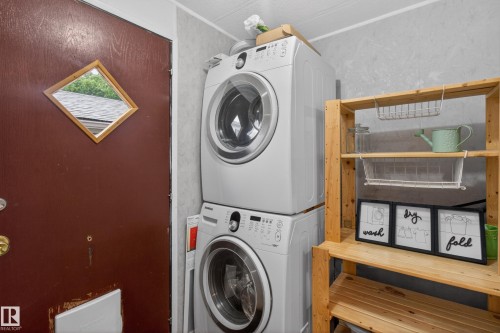 Dedicated laundry area featuring stacked front-loading washer and dryer units - 21 Willowdale Drive, Edmonton, AB - Indoor Photo Showing Laundry Room