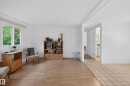 Living area with wood-finish flooring, white walls, and a large window - 21 Willowdale Drive, Edmonton, AB  - Indoor 
