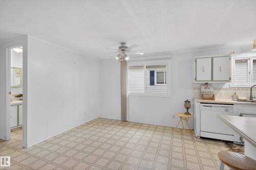 Kitchen area with white paneled walls, patterned tile flooring, and a ceiling fan - 21 Willowdale Drive, Edmonton, AB - Indoor Photo Showing Kitchen