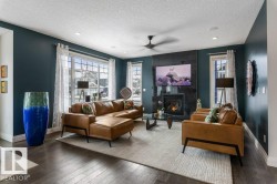 South West Facing Living Room featuring Large Windows, Dark Hard wood Flooring, and Tile Surround Gas Fireplace - 