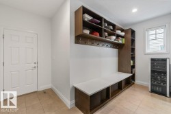 Rear Entryway featuring tile flooring, custom built-in storage with bench, and negotiable fridge - 