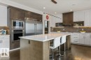Kitchen Features Dark Hardwood Flooring, Two Tone Kitchen Cabinets, Gas Stove, Wall Oven, and White Quartz Counters - 4476 Suzanna Crescent, Edmonton, AB  - Indoor Photo Showing Kitchen With Upgraded Kitchen 