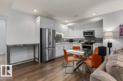 Basement Kitchen (Third Kitchen in the House) featuring Stainless Steel Appliances, White Cabinets, White Quartz Counters, and Tile Backsplash - 