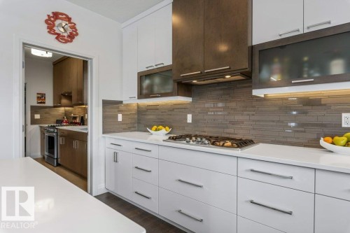 Kitchen Features Dark Hardwood Flooring, Two Tone Kitchen Cabinets, Gas Stove, Wall Oven, and White Quartz Counters - 4476 Suzanna Crescent, Edmonton, AB - Indoor Photo Showing Kitchen With Upgraded Kitchen
