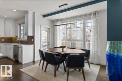 Open Concept Kitchen Eating Space featuring Dark Hardwood Flooring, Direct Access to Back Deck, and South Facing Windows - 