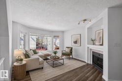 Living area featuring wood-finish flooring and a bay window - 