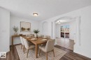 Dining area featuring wood-finish flooring, a wall niche, and an arched entryway with decorative columns - 6 1237 Carter Crest Road, Edmonton, AB  - Indoor Photo Showing Bedroom 