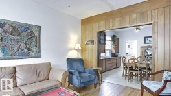 Living area with wood-finish flooring and a white painted wall - 